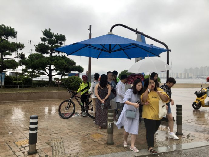 ゲリラ豪雨で雨宿りする人々