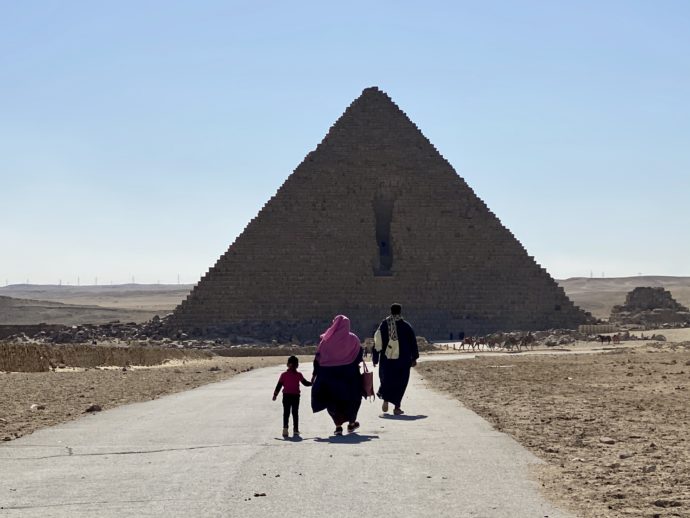 メンカウラー王のピラミッドの道を進む家族