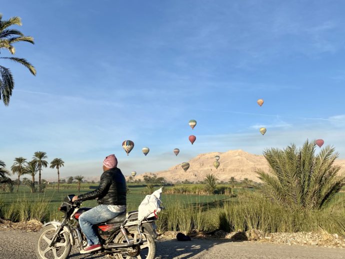 ルクソール西岸に浮かぶ熱気球とバイク
