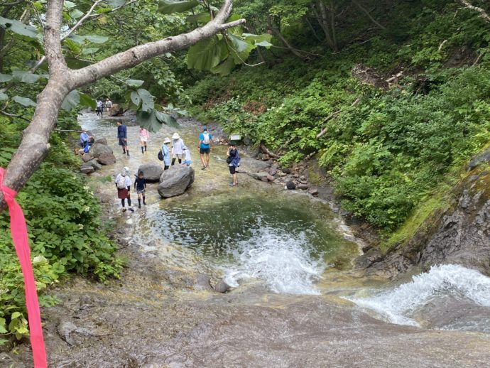 カムイワッカの滝に登ろうとする観光客