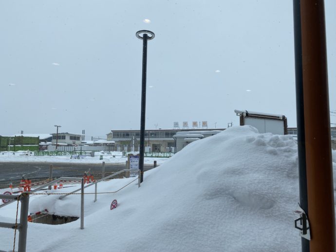 雪の山で隠れて見えないJR大館駅