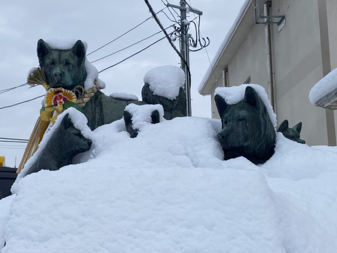 雪で埋もれる秋田犬の銅像