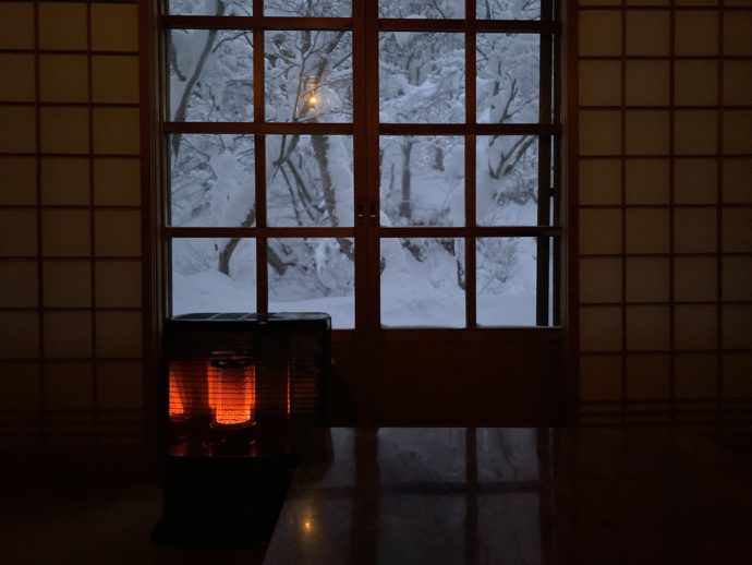 和室のストーブと雪景色