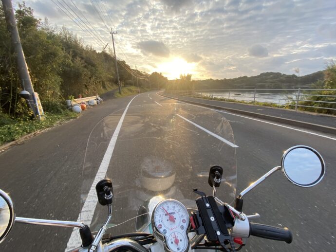 夕日の見える道路とバイク