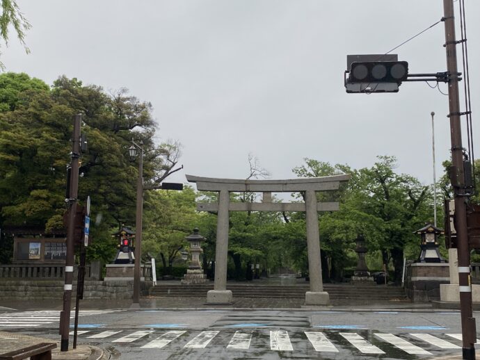 信号の向こうに見える鳥居と石碑