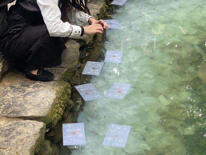 鏡の池に浮かぶ占い紙