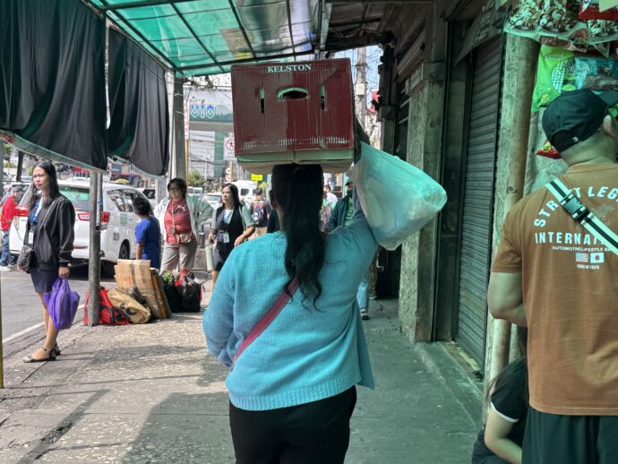 荷物を頭の上に乗せて運ぶ女性