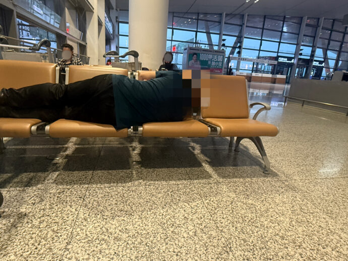 ベンチで眠る男性