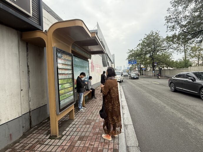 倪家堰站でバスを待つ女性