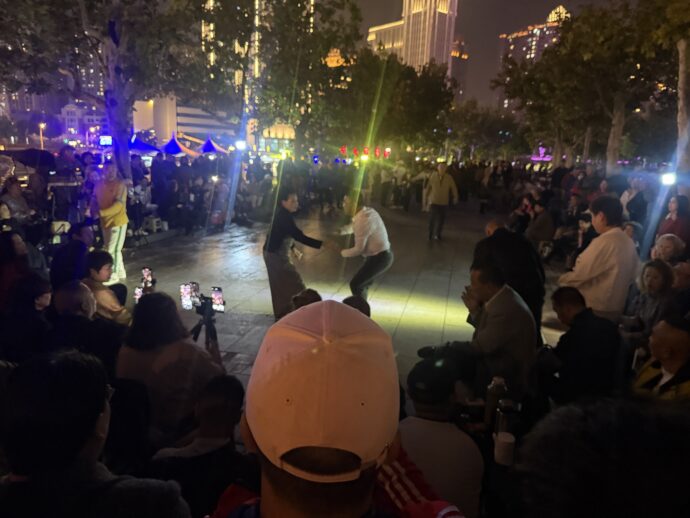 群衆のまえでダンスをする人々