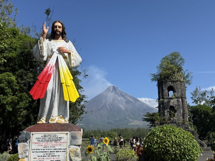 キリスト像とマヨン火山と鐘楼