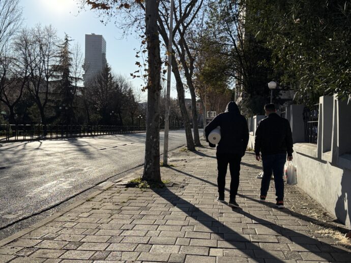 ブリリ地区の幹線道路を歩く男性