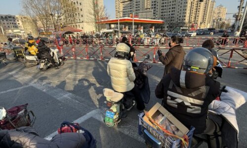 踏切待ちの人々