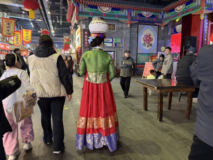 頭にツボを乗せた女性