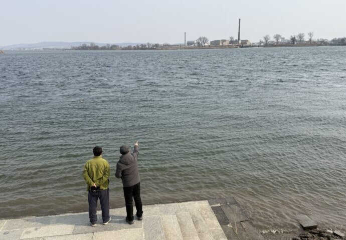 北朝鮮を眺める男性たち