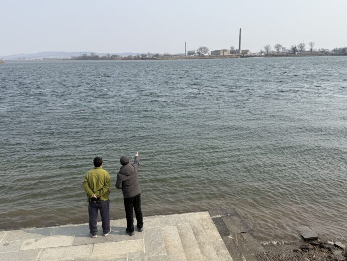 北朝鮮を眺める男性たち